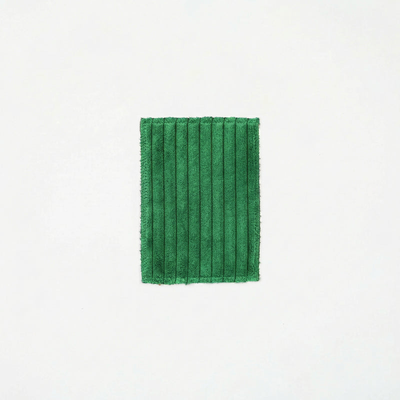 Green pleated fabric on a white background